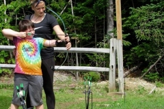 CIT helping camper with archery